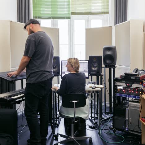 man and a woman creating music at their office with lots of professional instruments from Ableton.